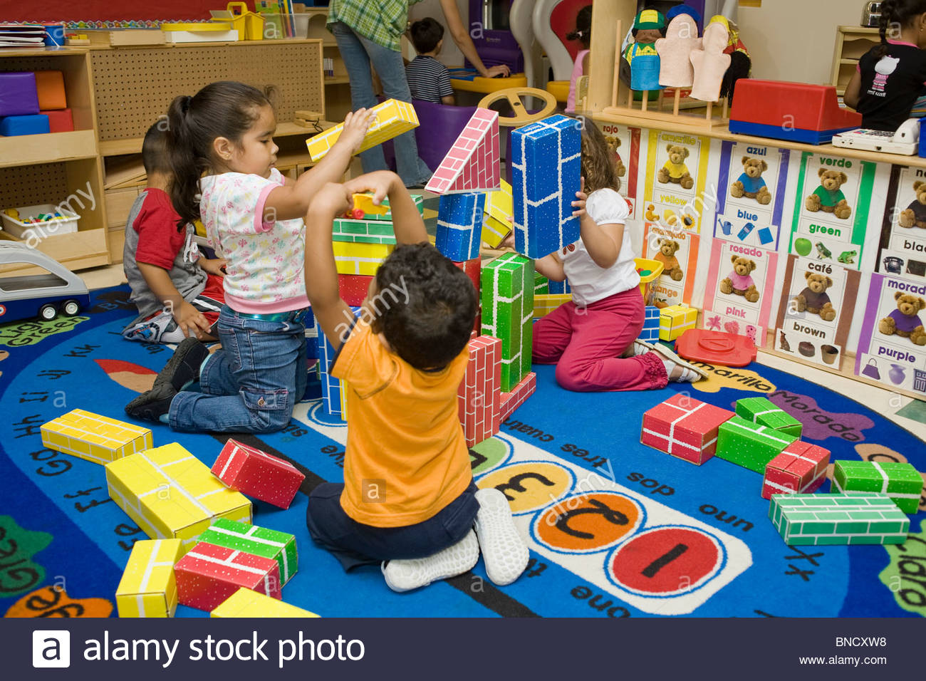 preschool children playing with blocks on the floor BNCXW8